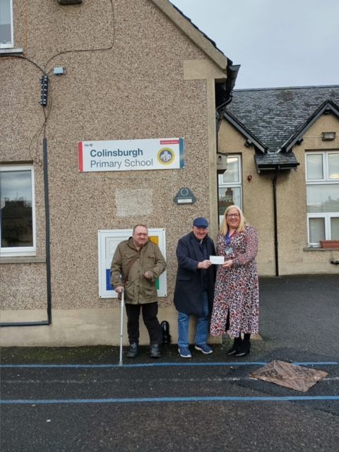 Lodge Secretary Ian Greig P.M. presenting cheque for £365 to Colinsburgh Head Teacher Mrs. McBain